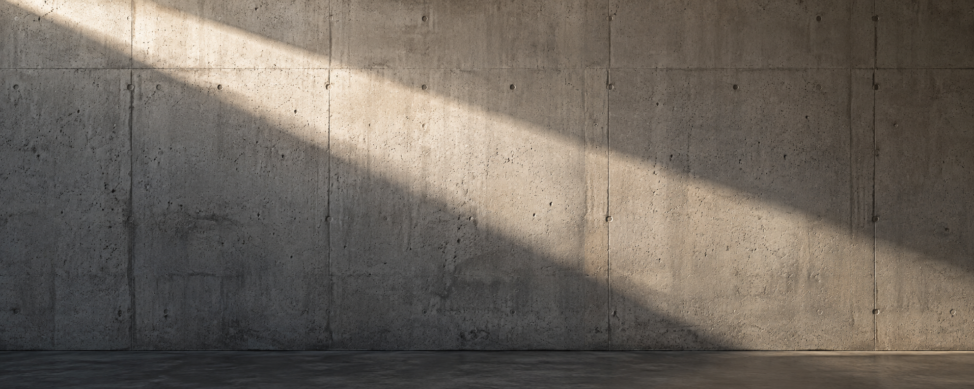 Warm daylight crossing a precise cast concrete wall